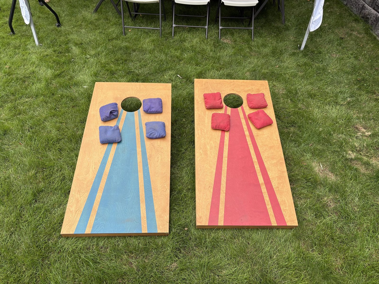 Two colorful cornhole boards with beanbags