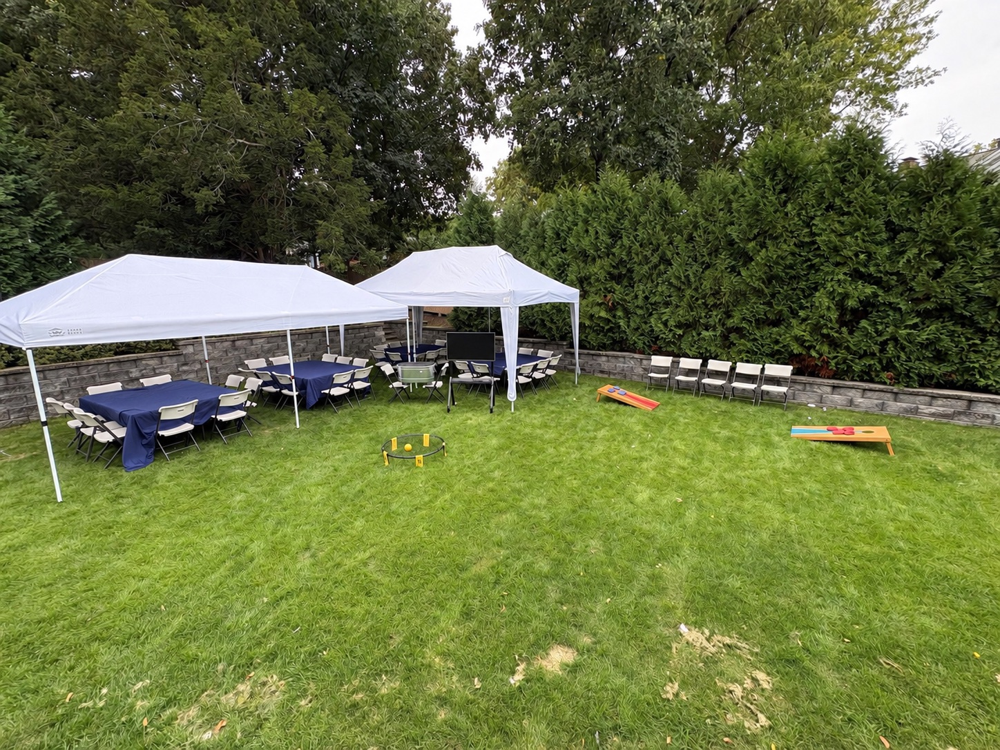 Bongo tents, seating, and optional yard games set up across a backyard