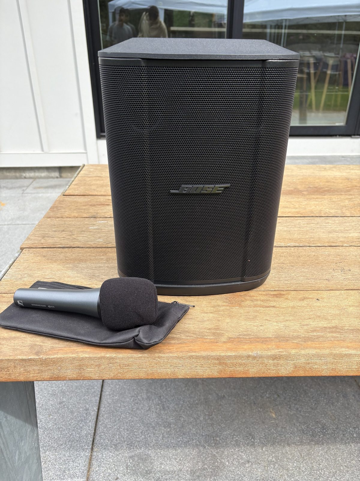Black speaker and handheld microphone on a table